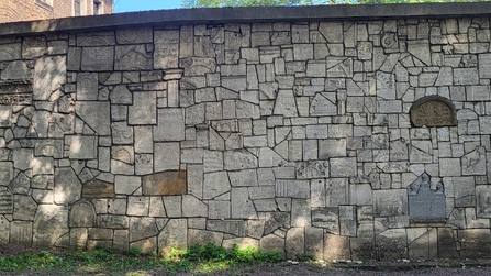 Die Mauer wurde mit zerstörten Grabsteinen gestaltet
